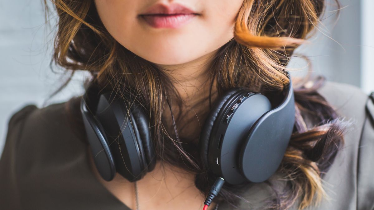 mulher com headphone no pescoço